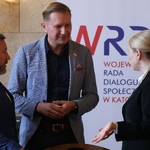 Uczestnicy obrad Wojewódzkiej Rady Dialogu Społecznego. Dwóch mężczyzn oraz kobieta rozmawiają ze sobą.