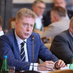 Osoby siedzące przy stole w sali konferencyjnej podczas spotkania